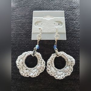 Hand made crochet earrings in silver with metallic flecks, and light blue bead.